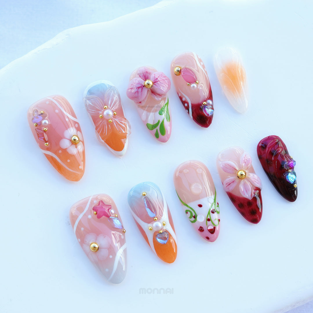 Grace vintage floral press-on nails in soft nude, pink, orange and burgundy, laid out with gem accents