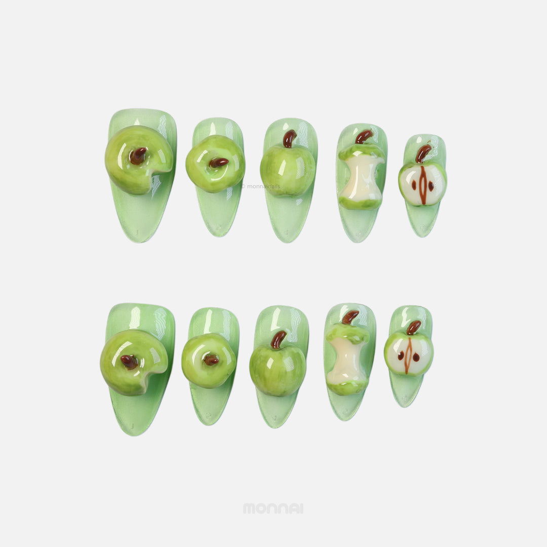 Green Apple press-on nails laid out in a playful 3D apple theme with glossy green sculpted details and bitten slices