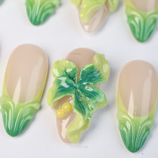 Green Bloom press-on nails laid out with sheer nude bases, soft green tips and a 3D floral accent in fresh floral detail.