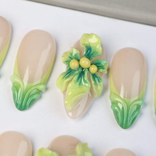 Green Bloom press-on nails with sheer nude bases, green French tips, and a 3D floral accent in close-up