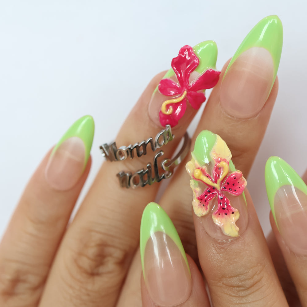 Green Fantasy press-on nails on hand, jelly nude pink base with neon green French tips and 3D floral accents.