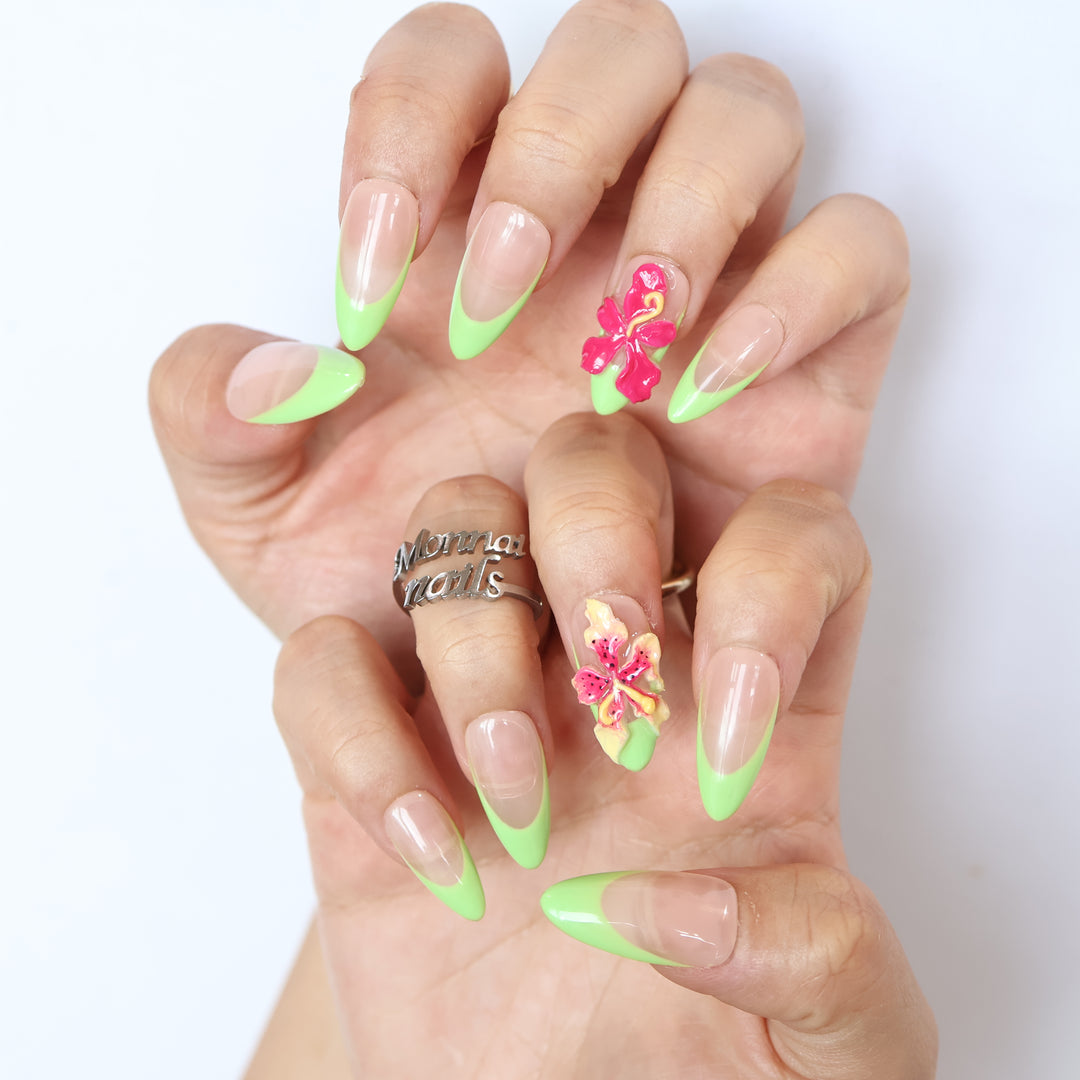 Green Fantasy press-on nails worn on hands, showing jelly nude pink bases with soft green French tips and 3D floral accents.