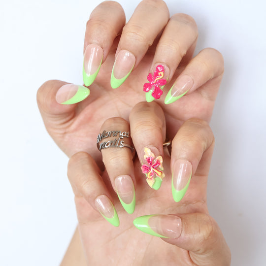 Green Fantasy press-on nails worn on hands, showing jelly nude pink bases with soft green French tips and 3D floral accents.