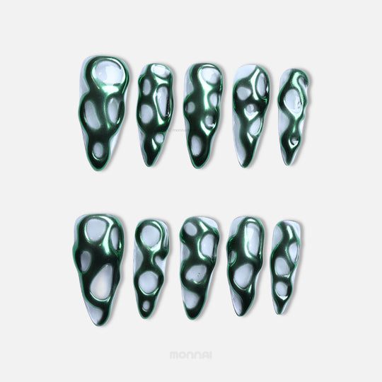 Green Flow press-on nails laid out in a full set, with metallic green chrome flowing over a clear base in an abstract sculptural pattern.