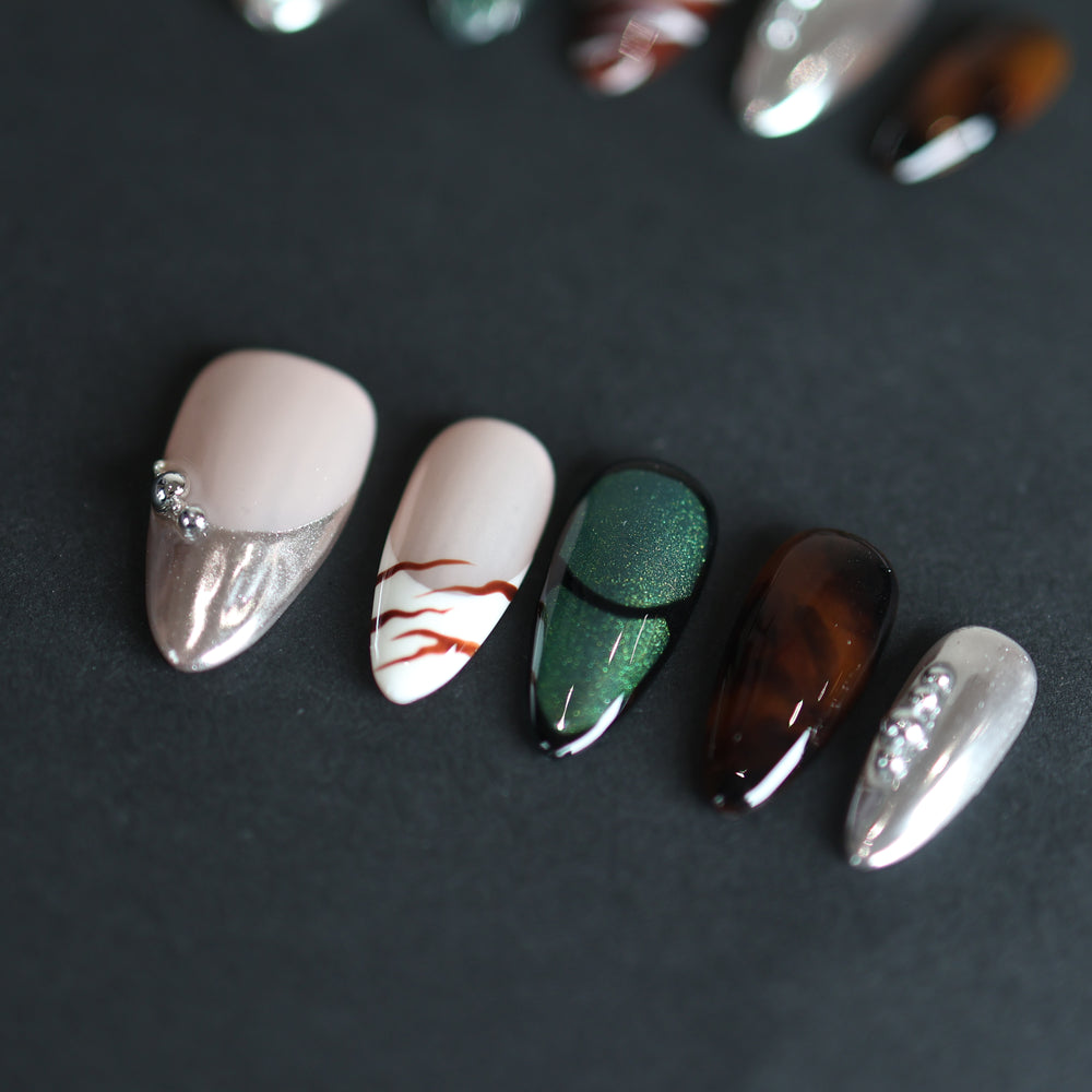 Green Light press-on nails with green cat-eye, amber tortoiseshell and silver chrome on a nude base