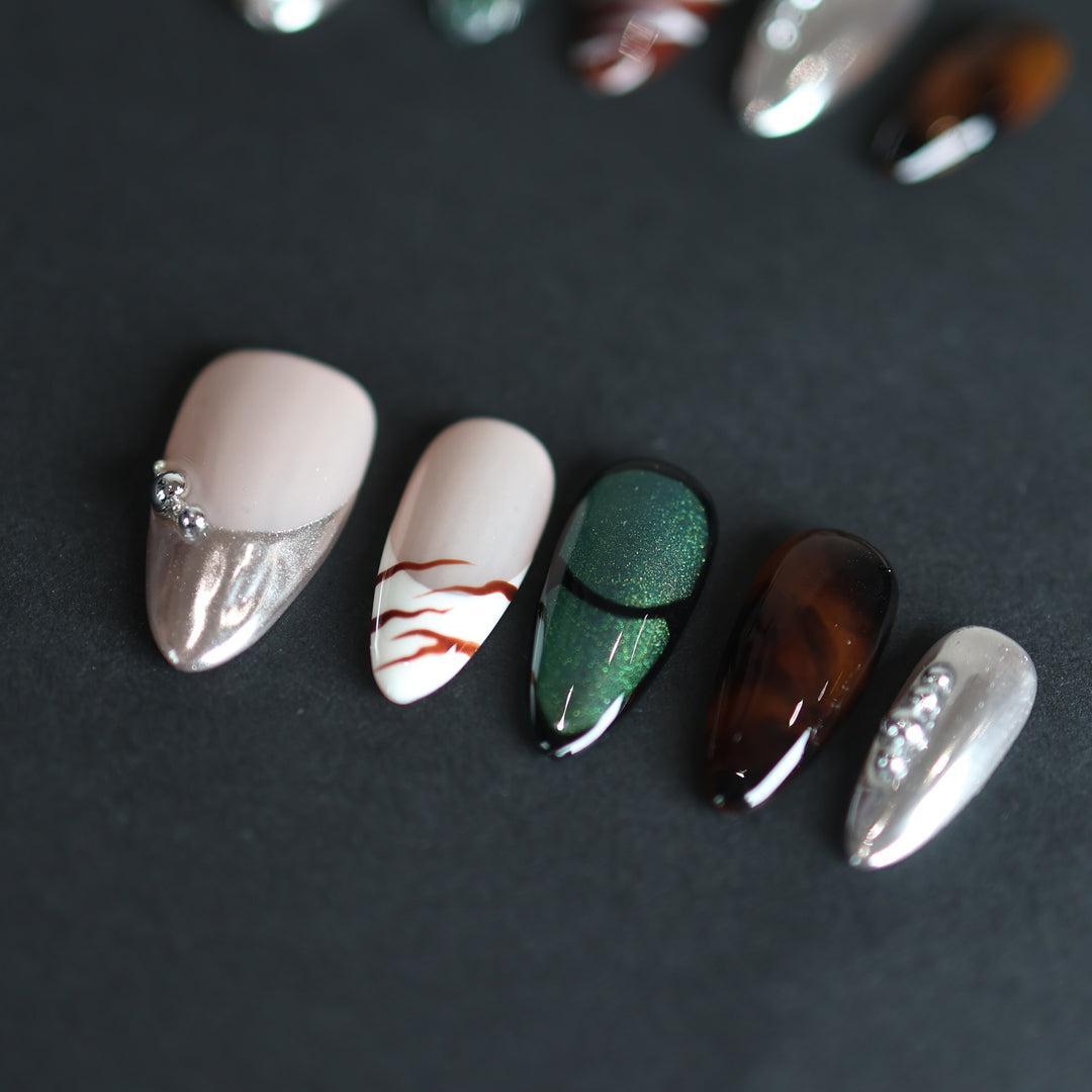 Green Light press-on nails with green cat-eye, amber tortoiseshell and silver chrome on a nude base