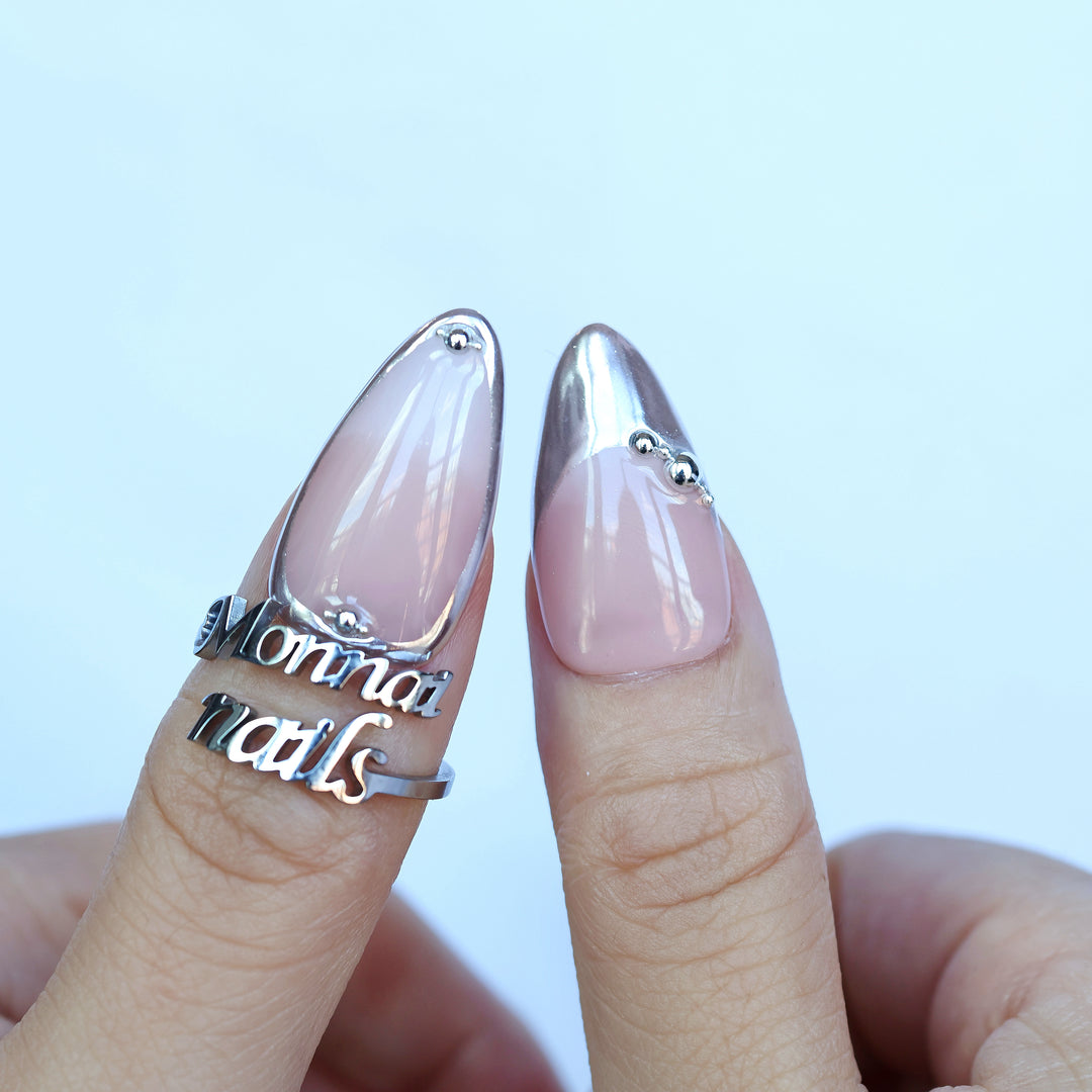 Green Light press-on nails shown on fingers, with pink nude base, silver chrome tips, and bead accents.
