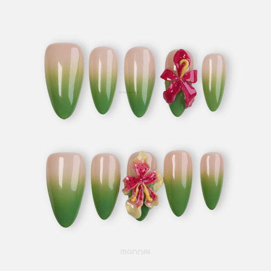 Green Sprout press-on nails with nude-to-green ombré and 3D orchid details, shown laid out in close-up