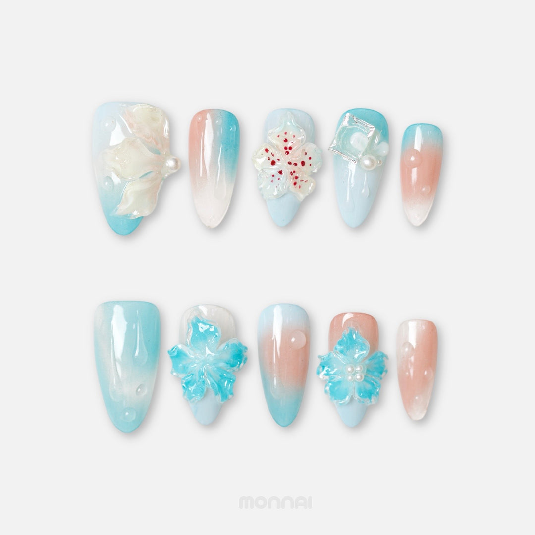 Icy Petals press-on nails shown laid out, with glossy blue and blush gradients, translucent 3D flowers, and bubble accents.