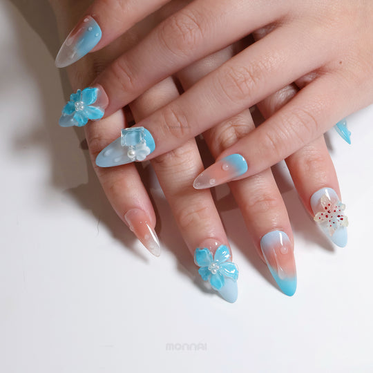 Icy Petals press-on nails worn on hands, with blue-pink gradients, glossy gel shine, and translucent 3D floral accents.