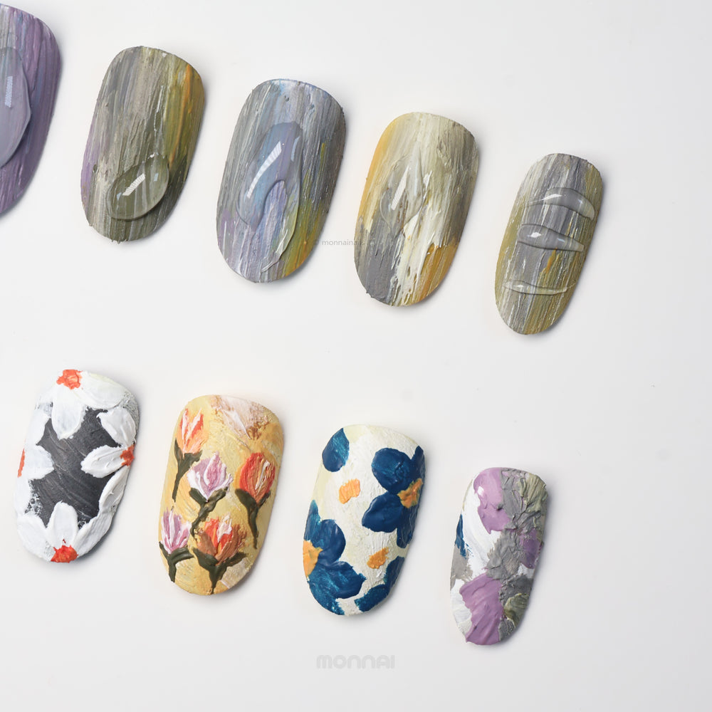 Impressionist Garden press-on nails shown laid out with layered brushstrokes, textured florals, and matte canvas-like finishes.