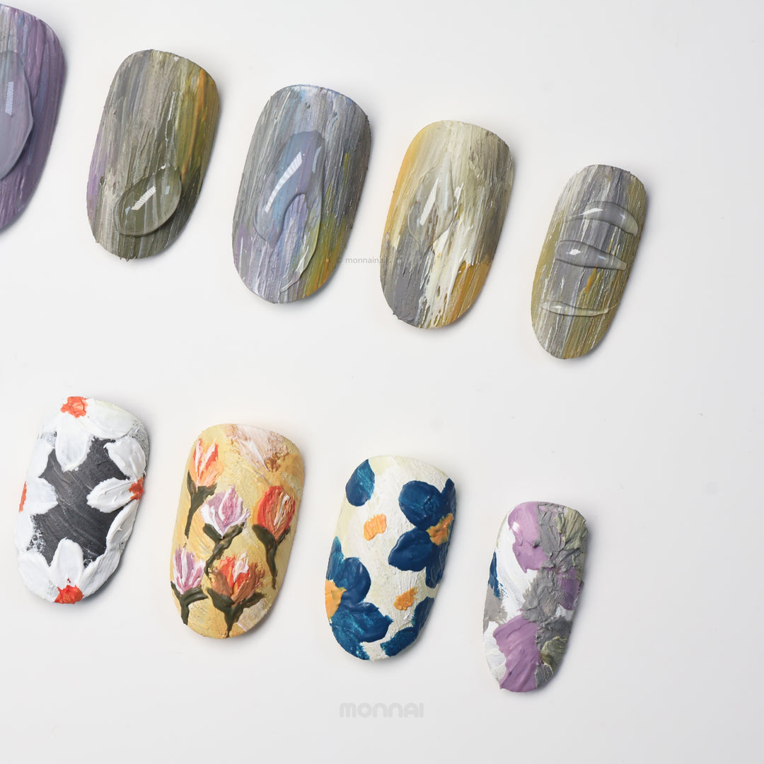 Impressionist Garden press-on nails shown laid out with layered brushstrokes, textured florals, and matte canvas-like finishes.
