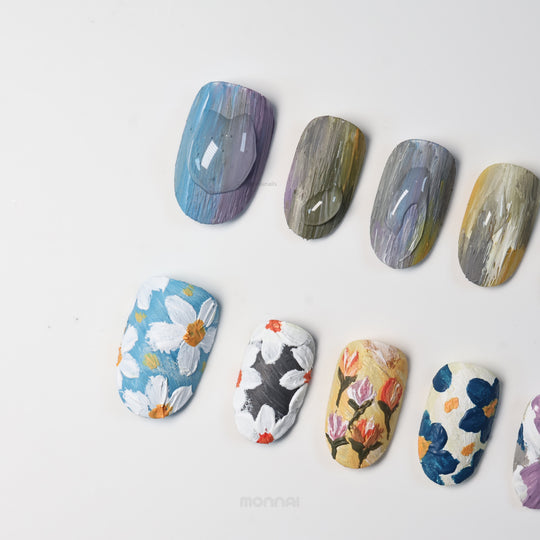 Impressionist Garden press-on nails laid out with textured, painterly floral designs and matte canvas-like finish.