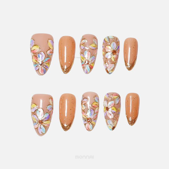 Iridescent Petals press-on nails laid out with pastel floral stained-glass petals and gold French tips