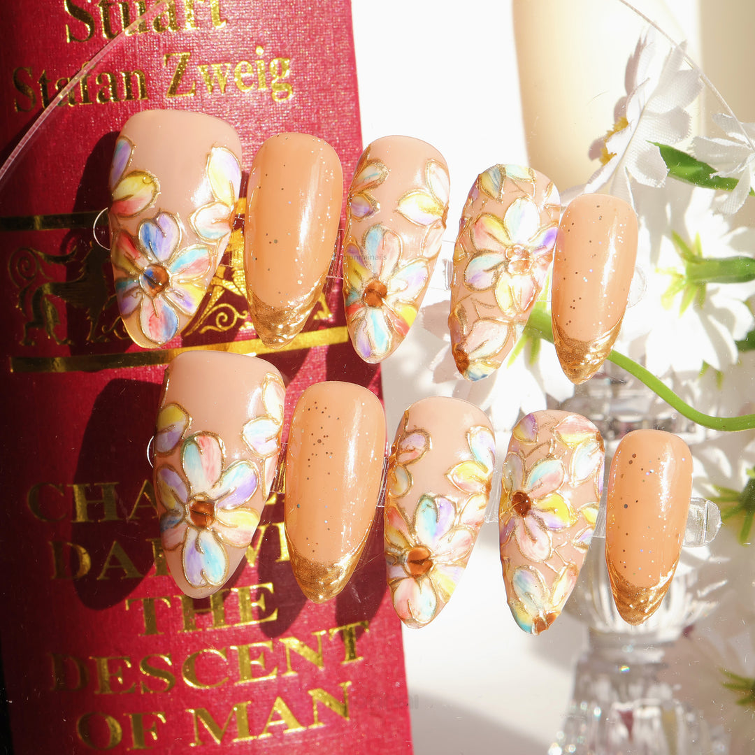Iridescent Petals press-on nails shown on a display card, with pastel floral stained-glass petals and gold glitter French tips.