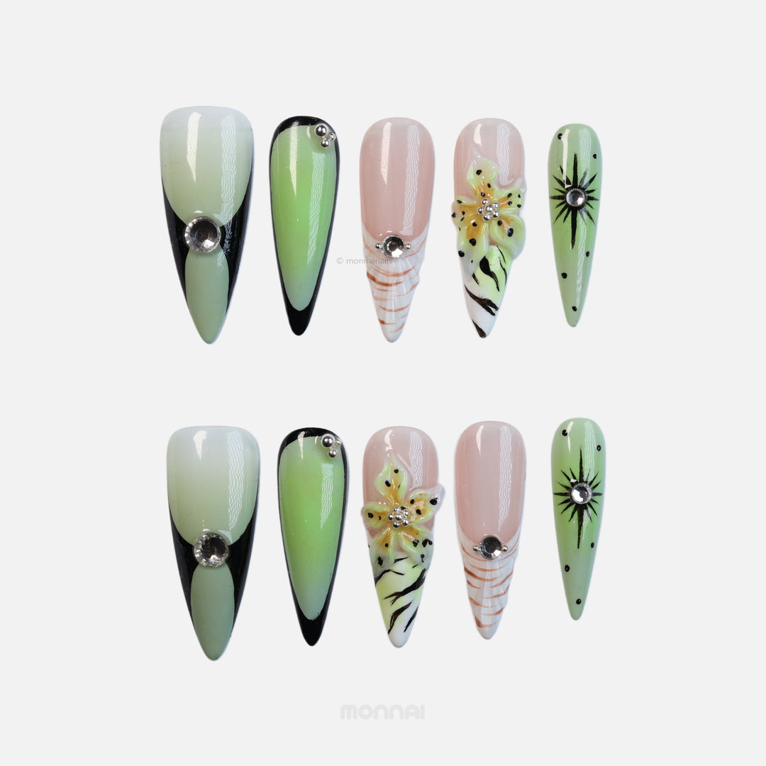 Jade Lotus press-on nails laid out with matcha green, nude, black accents, starbursts, floral details, and crystals