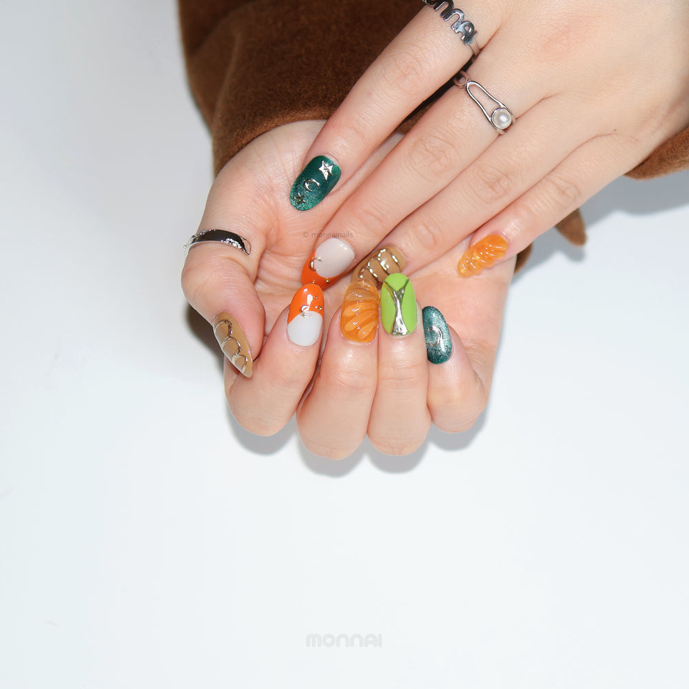 Jungle Glow press-on nails shown on hands, with retro olive green, burnt orange and chrome accents.