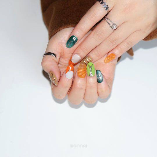 Jungle Glow press-on nails shown on hands, with retro olive green, burnt orange and chrome accents.