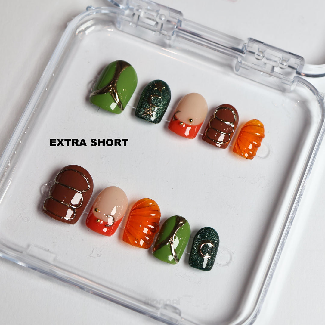 Jungle Glow press-on nails laid out in extra short retro style with olive green, burnt orange, brown and chrome accents
