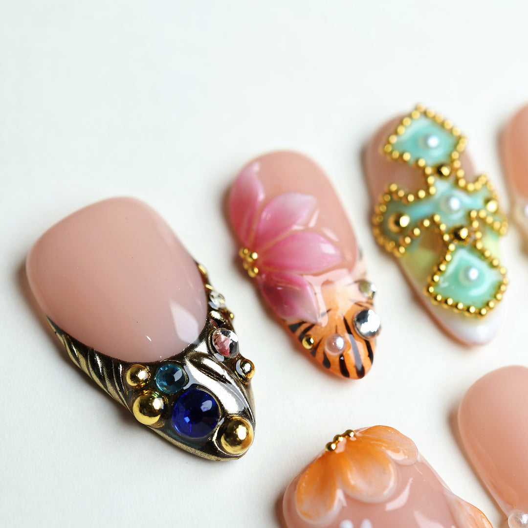 LUX press-on nails laid out with hand-painted floral art, 3D petals, and colorful rhinestones in an eclectic summer-inspired set.