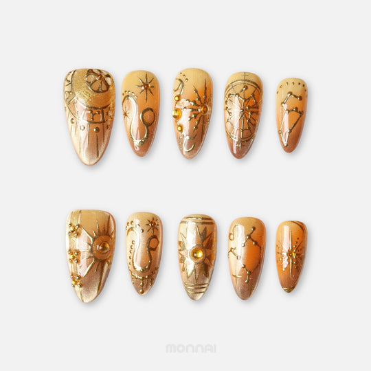 Leo press on nails from the Zodiac Collection, featuring warm gold and amber tones, lion motifs, sun details and celestial constellation accents.
