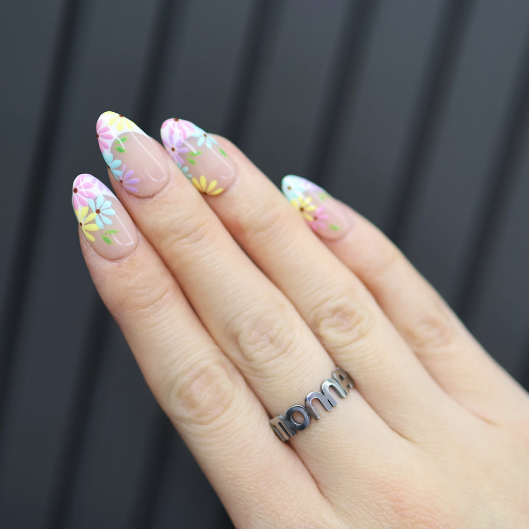 Little Daisy press-on nails on-hand view with pastel floral French tips and sheer nude base