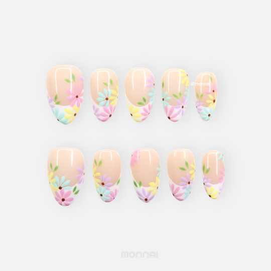 Little Daisy press-on nails laid out with pastel daisy floral tips on nude bases, glossy finish
