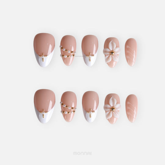 Love Story press-on nails in soft nude and white French tips with pearl and gold bead accents, 3D floral detail