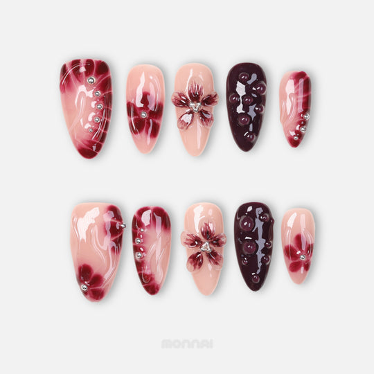 Lover’s Kiss press-on nails with sheer nude pink, burgundy florals, silver beads and jelly droplets in a moody romantic set