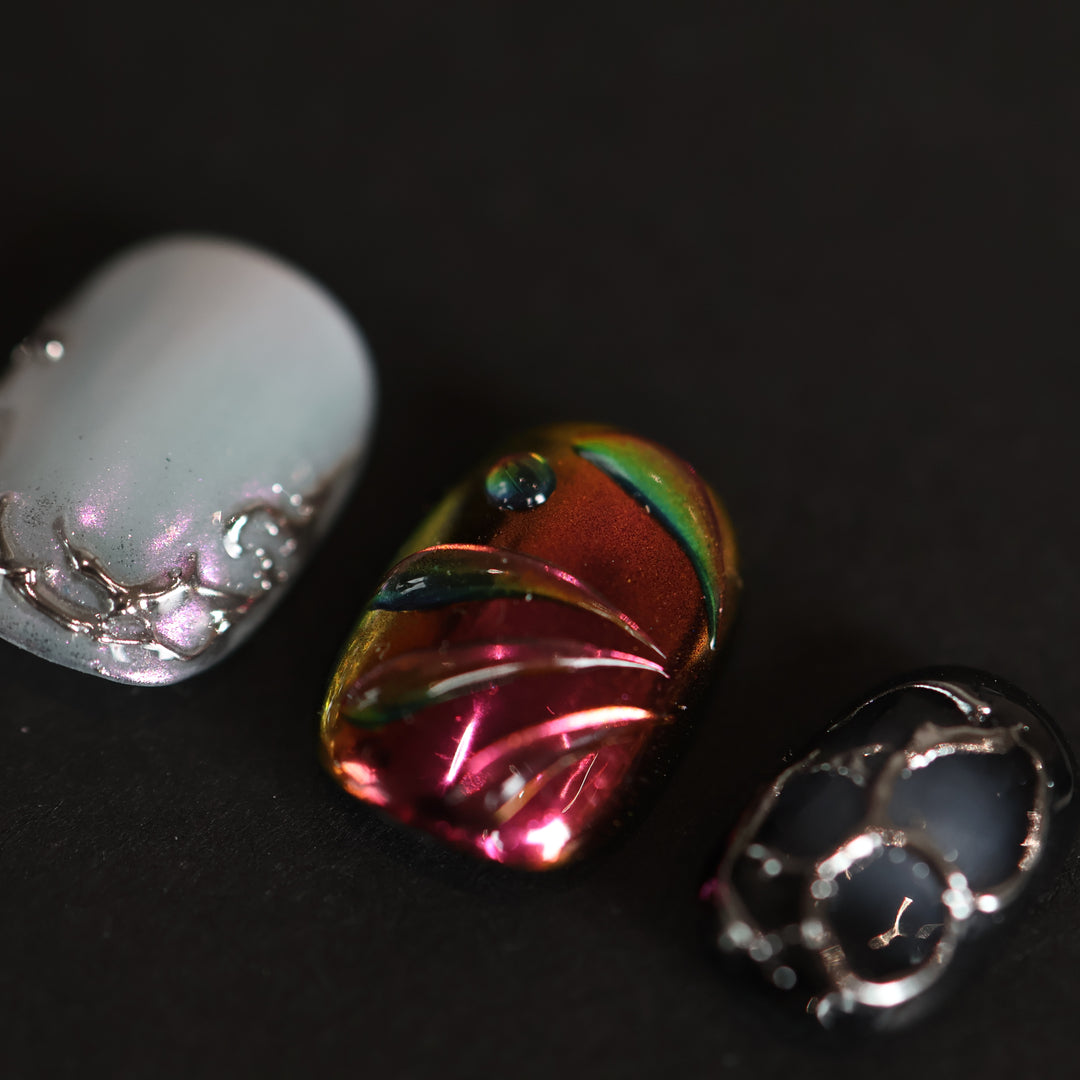 M-Code press-on nails in cyber-goth rebellion style, close-up of silver chrome thorns, iridescent shell texture and multichrome accents