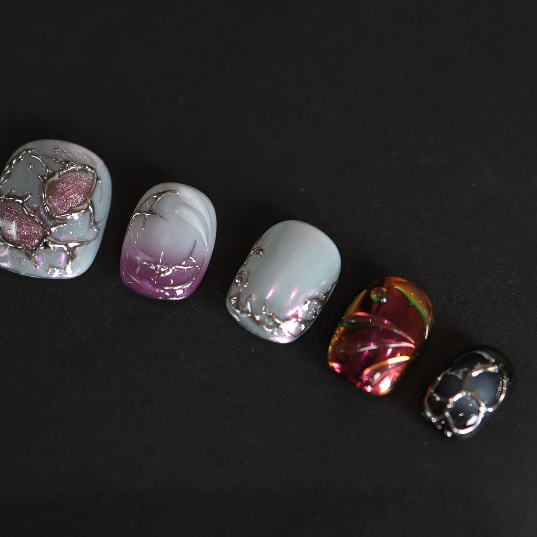 M-Code Cyber-Goth Rebellion press-on nails laid out with purple aura, molten silver thorns, and multichrome accents