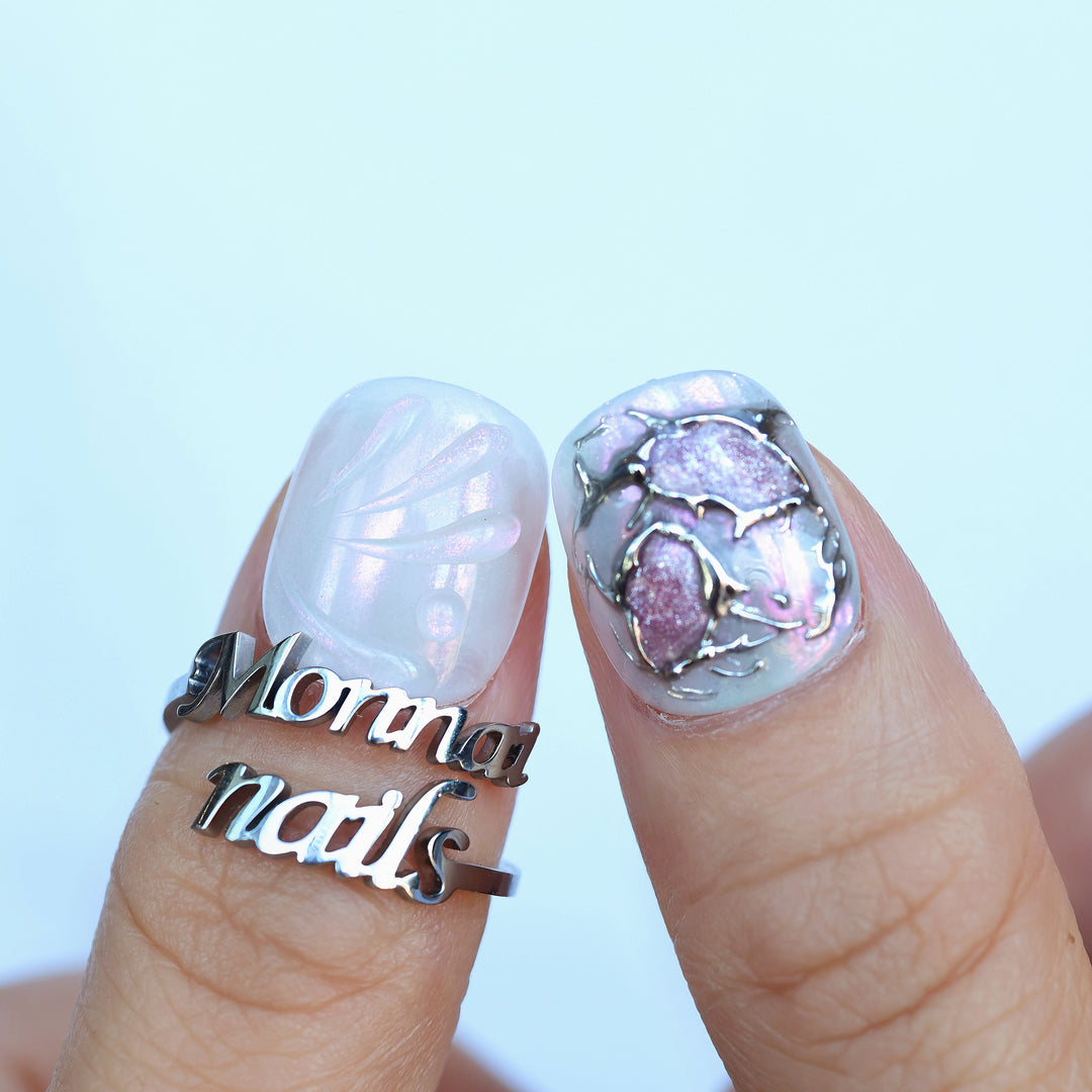 M-Code Cyber-Goth Rebellion press-on nails shown on fingers with iridescent shell texture and molten silver chrome accents.