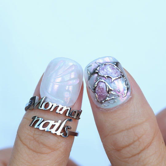 M-Code Cyber-Goth Rebellion press-on nails shown on fingers with iridescent shell texture and molten silver chrome accents.