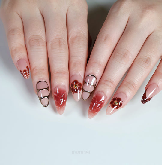 Maple Glow press-on nails on hands, nude and brown glossy florals with fine linework and subtle vintage style.