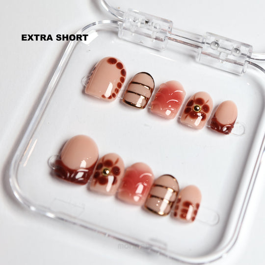 Maple Glow extra short press-on nails laid out with nude, brown floral, and gold striped glossy vintage designs