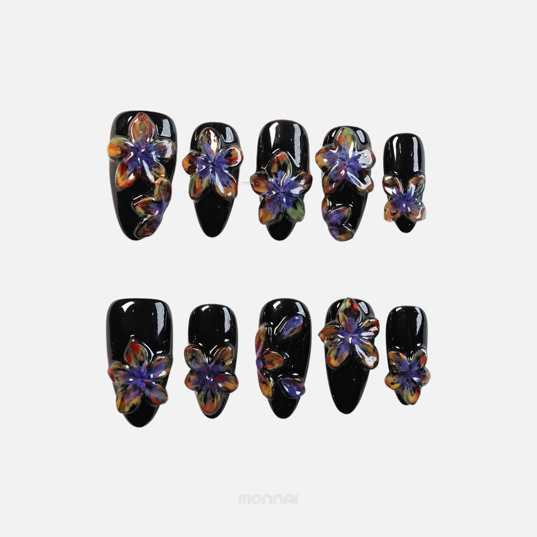 Midnight Violet press-on nails laid out with glossy black bases and sculpted 3D floral blooms in bold artistic contrast.