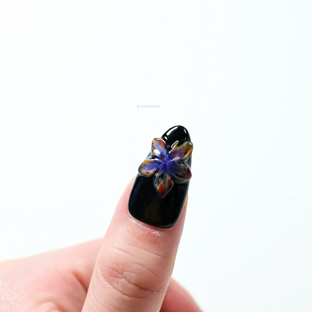 Midnight Violet press-on nails worn on hand, glossy black base with sculpted 3D flower and bold artistic blooms.