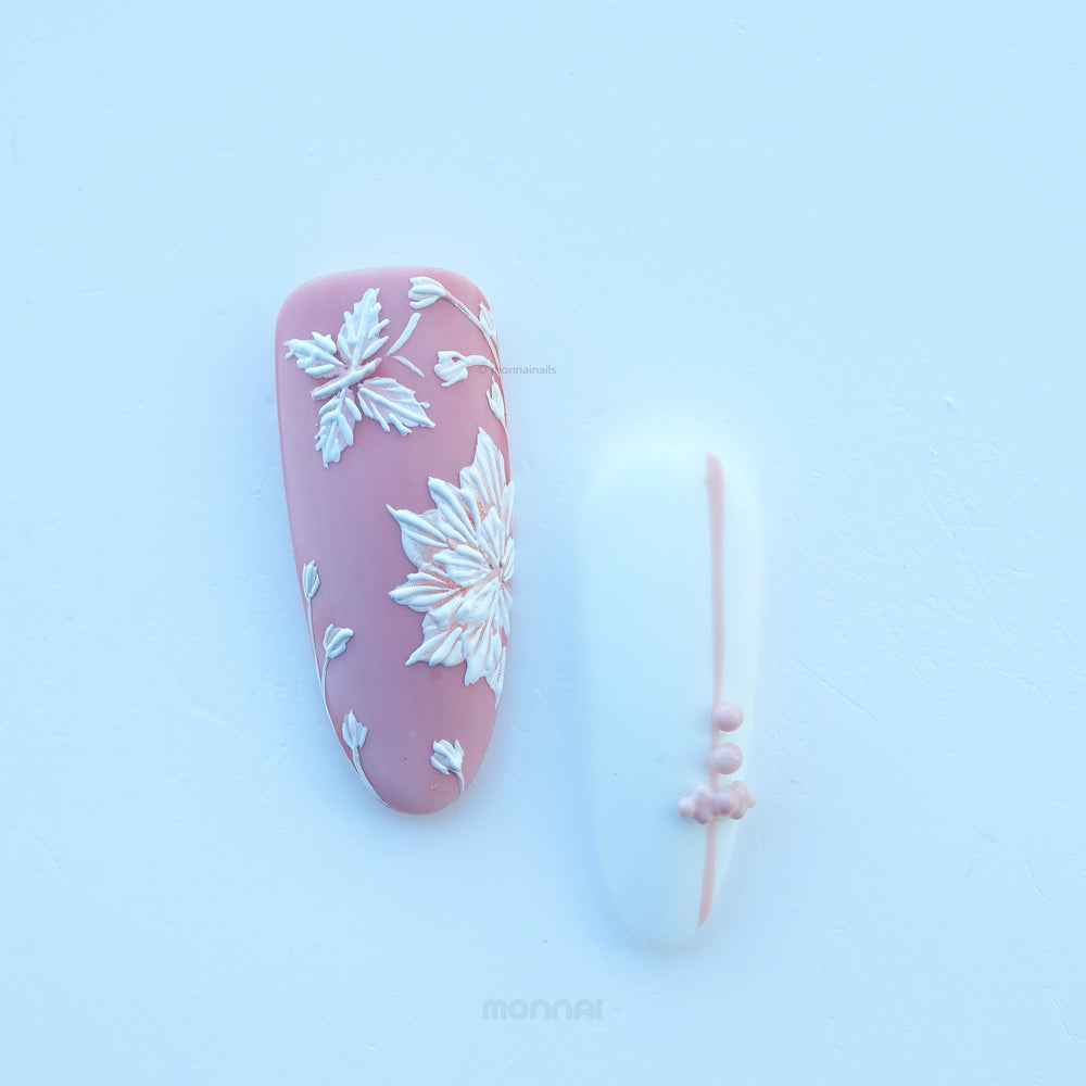 Morning Dew press-on nails with muted pink matte floral detail and a pale blue accent nail, shown laid out with bead accents