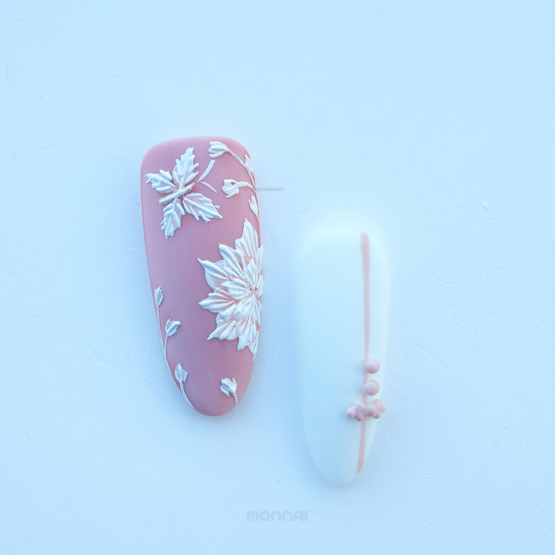 Morning Dew press-on nails with muted pink matte floral detail and a pale blue accent nail, shown laid out with bead accents