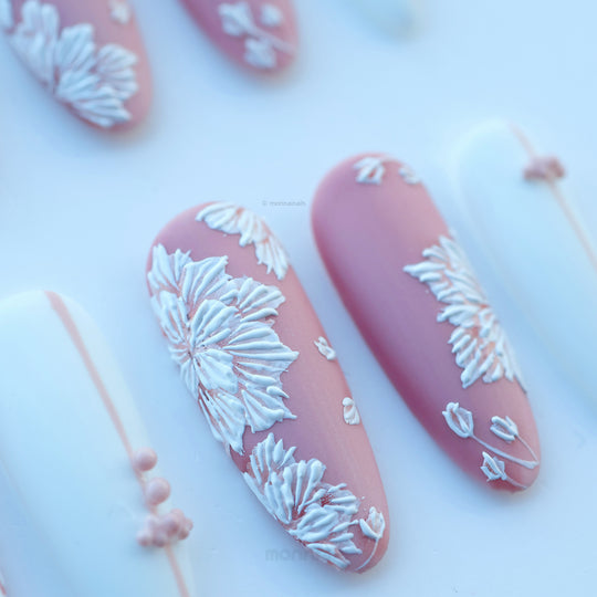 Morning Dew press-on nails in close-up, matte pink with white floral stitched details and soft bead accents.