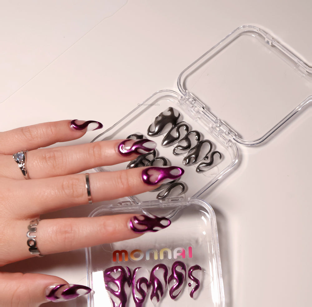 Mystic Flow press-on nails worn on hand, metallic purple chrome 3D swirls with negative space hearts