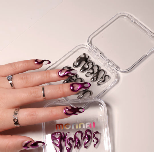 Mystic Flow press-on nails worn on hand, metallic purple chrome 3D swirls with negative space hearts