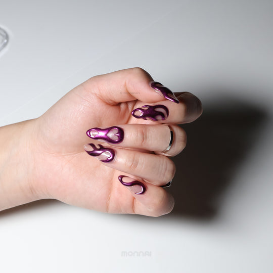 Mystic Flow press-on nails worn on hand, metallic purple chrome with 3D flowing swirls and heart motifs