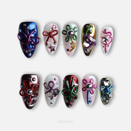 Neon Knots press-on nails in Y2K-inspired mirror chrome with wire bows, pearls, and butterfly accents