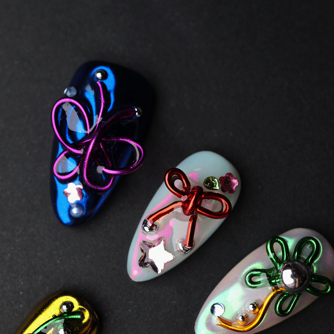 Neon Knots press-on nails laid out in close-up, with blue, white, and iridescent Y2K butterfly and bow accents.