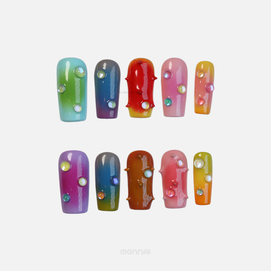 Neon Studs press-on nails laid out in close-up, with mismatched aura gradient colors, 3D studs, and iridescent bead accents.