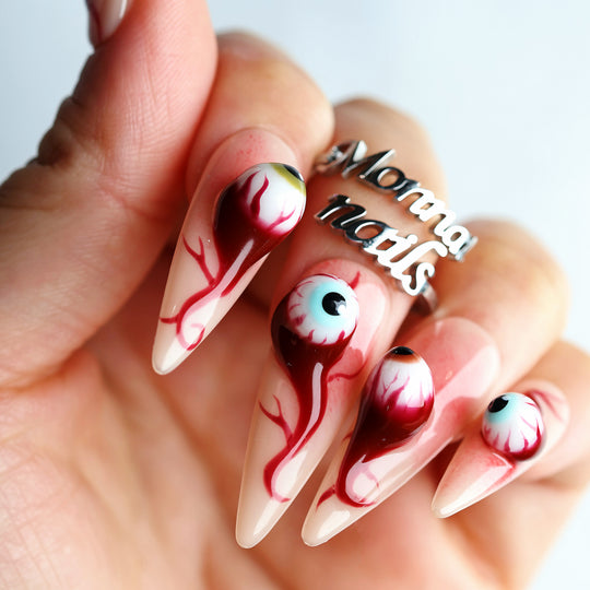 O-O press-on nails worn on hand, surreal grotesque eye design with blood-red veins and high-gloss finish