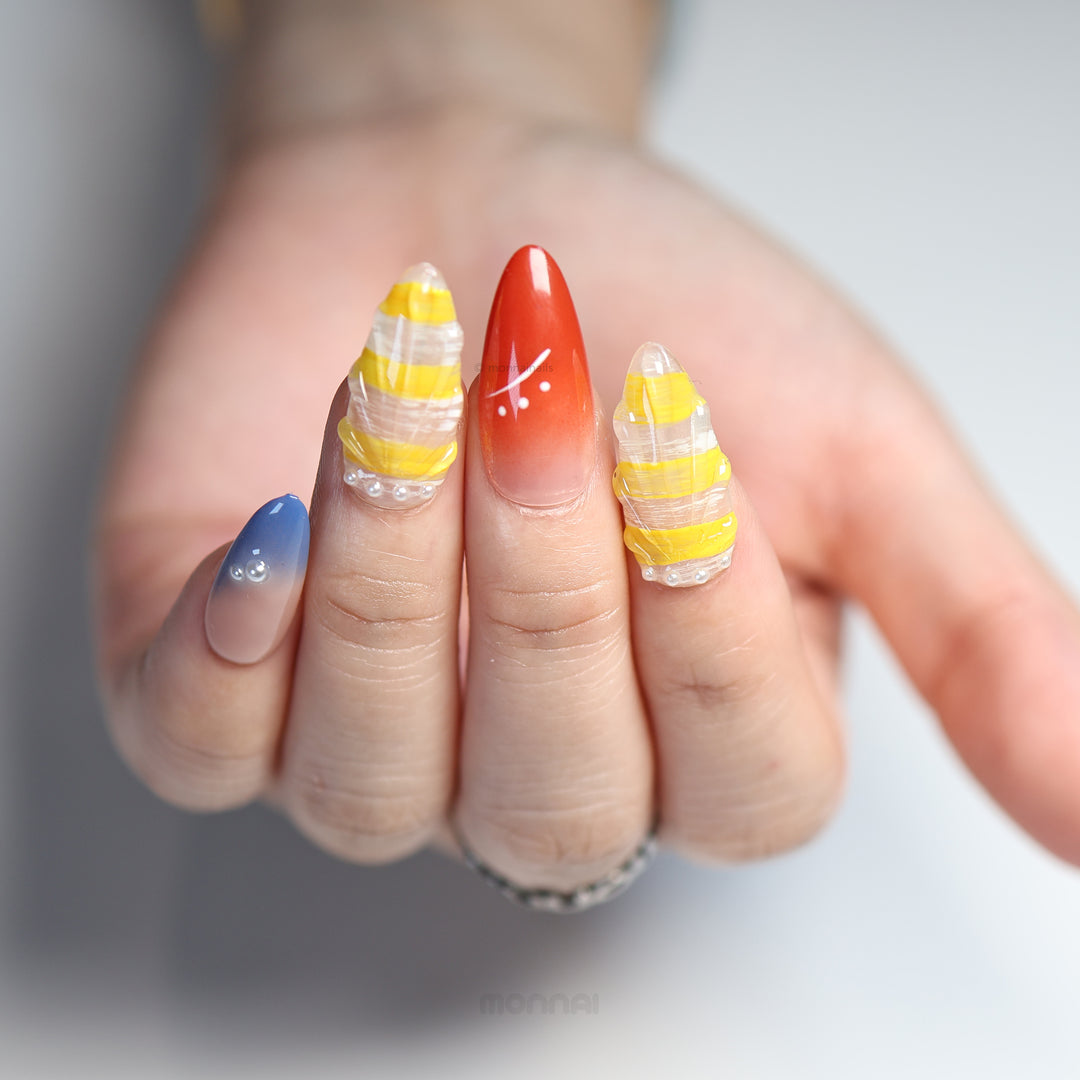Ocean Bloom press-on nails worn on hand, with sunny yellow stripes, blue gradient, red accent, and pearl beads