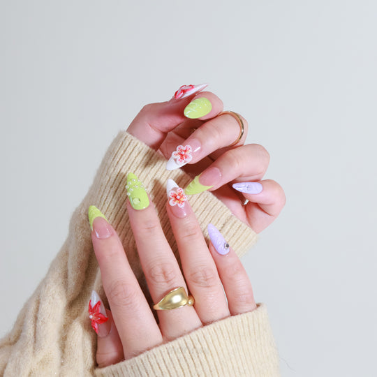 Orchid Glow press-on nails on hands with neon green and lavender 3D floral accents, shown in close-up