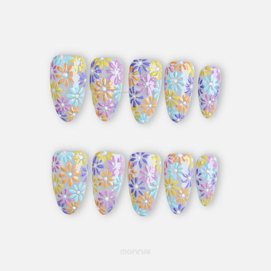 Pastel Meadow press-on nails laid out with milky white base, hand-painted pastel flowers, and raised gel texture.